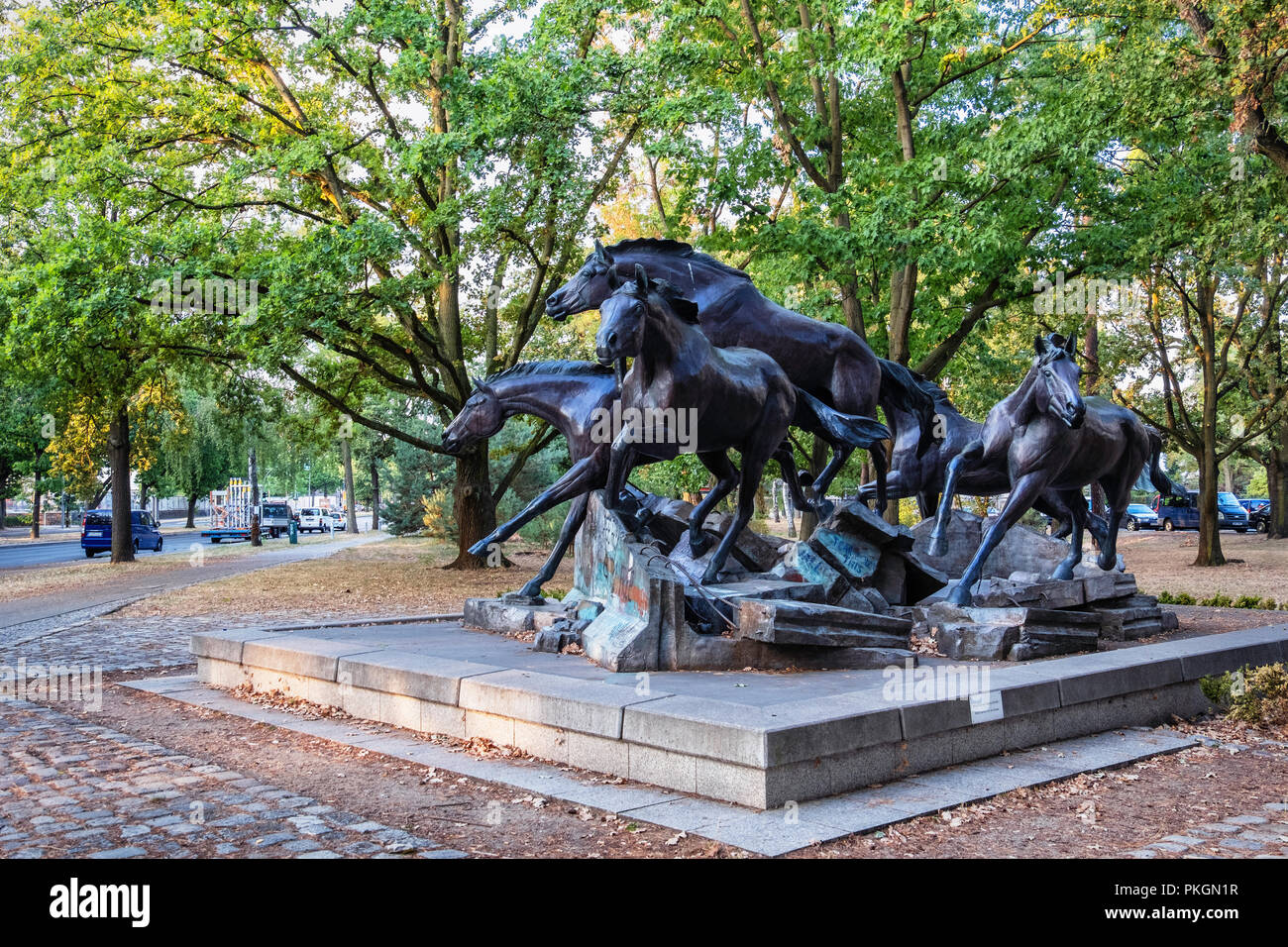 Berlin, Dahlem. Bronze Skulptur von Fünf wilde Pferde über Reste der Berliner Mauer springen. Geschenk aus den USA in die FDR erinnert an den Tag, an dem die Mauer fiel Stockfoto