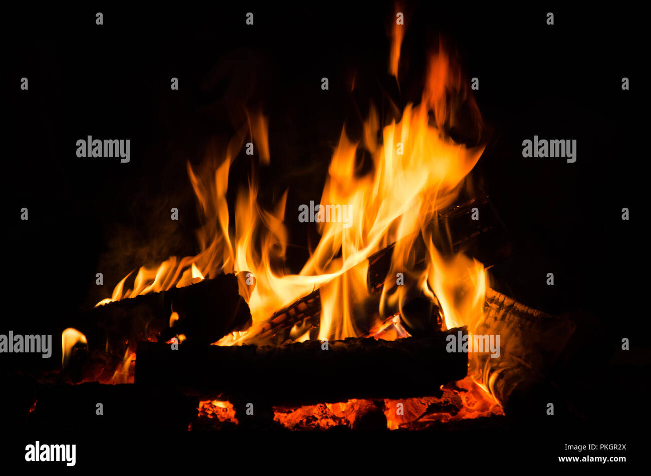 Das Verbrennen von Holz in der Nacht. Lagerfeuer an touristischen Camp an der Natur in den Bergen. Flamme amd Feuer Funken auf dunklen Abstrakt Hintergrund. Kochen Grill im Freien. Stockfoto
