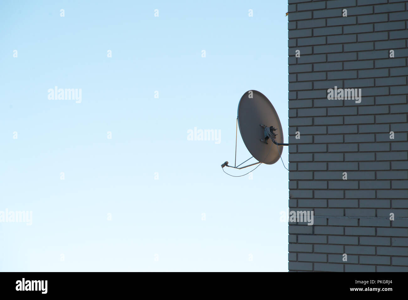 Satellitenschüssel auf dem Brick Wall Stockfoto