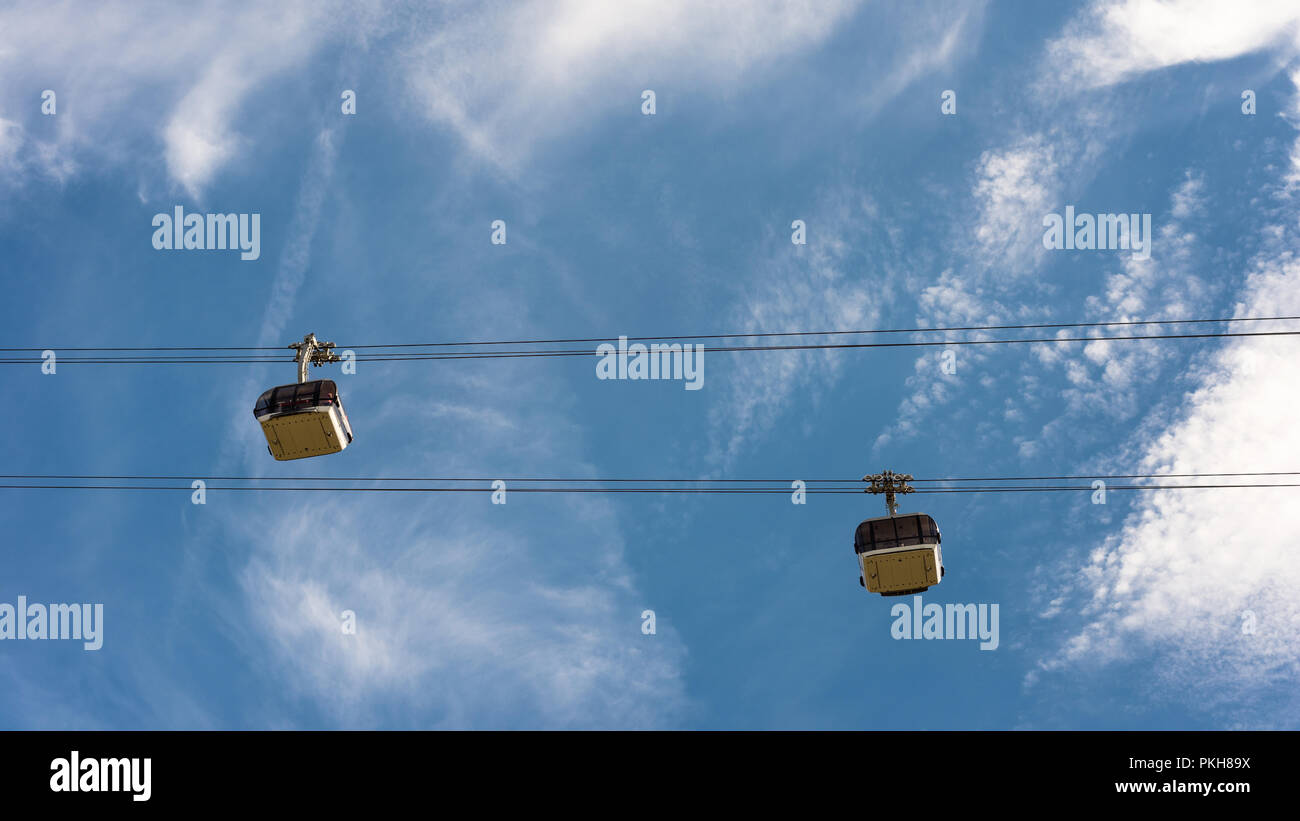 Seilbahn mit Wagen auf dem Hintergrund der blauen Himmel mit Wolken. Stockfoto