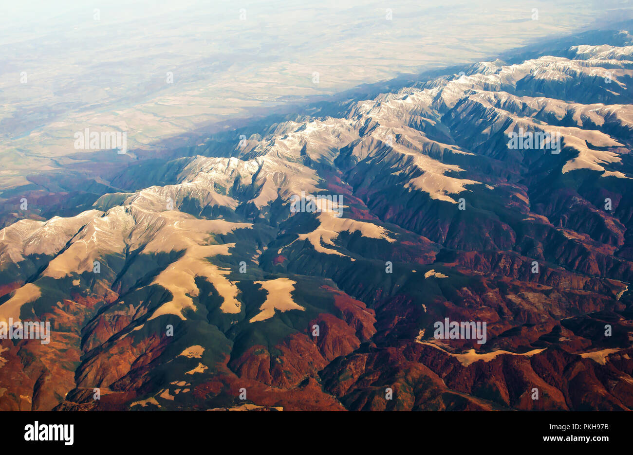Luftaufnahme von majestätischen Karpaten Gebirge mit schneebedeckten Gipfeln und Hügeln, grünen und roten Wald, Felder. Sonnigen, wolkenlosen Herbst Tag. Shot Abo Stockfoto