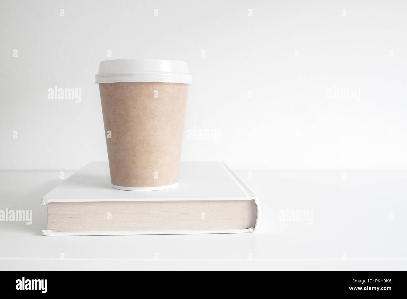 Warme Getränke Tasse mit Kaffee auf einem Buch. Prüfung Zeit für Bildung und Zeit Studie Konzept gegen eine leere weiße Kopie Raum Hintergrund. Stockfoto