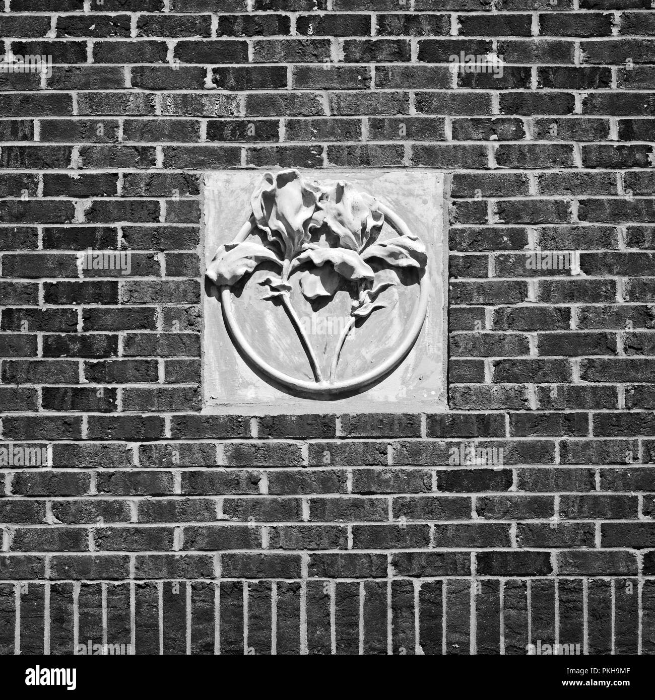 New Orleans, LA USA - Mai 9, 2018 - Konkrete Blume auf Red Brick Wall Tulane Universität B&W Stockfoto