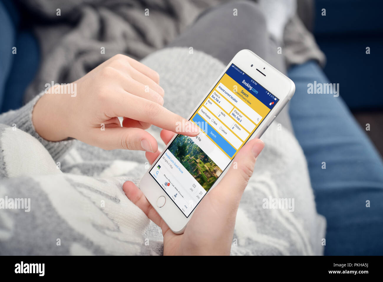 Kiew, Ukraine - Januar 24, 2018: Frau mit Booking.com App auf Apple iPhone 8 Plus zu Hause. Booking.com ist eine sehr beliebte Hotel Buchungssystem in E Stockfoto