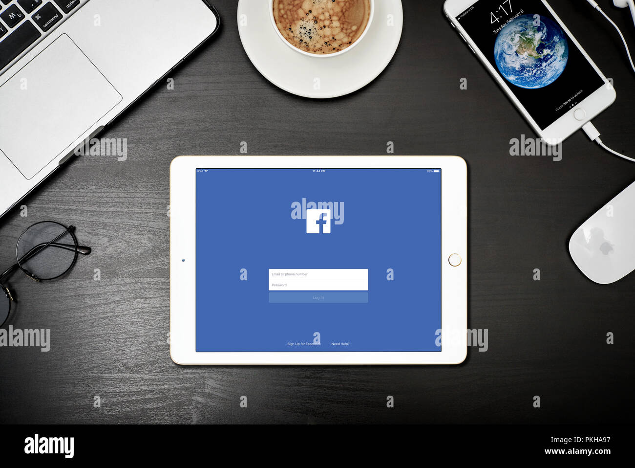 Kiew, Ukraine - Februar 6, 2018: Apple iPad Gold mit Facebook App auf dem Bildschirm auf schwarz Schreibtisch mit dem MacBook und iPhone, Top View. Facebook ist ein soziales Stockfoto