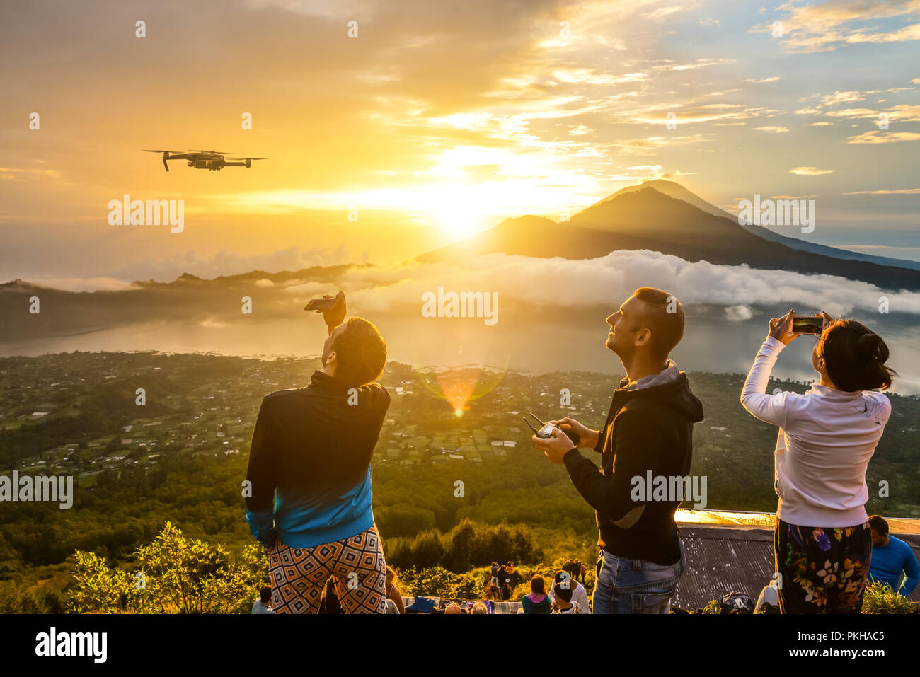 BALI, Indonesien - Januar 7, 2018: Die Gruppe der jungen Leute zu beobachten die Dämmerung auf den Batur Vulkan auf Bali, Indonesien. Und einer von ihnen pilotes UAV co Stockfoto