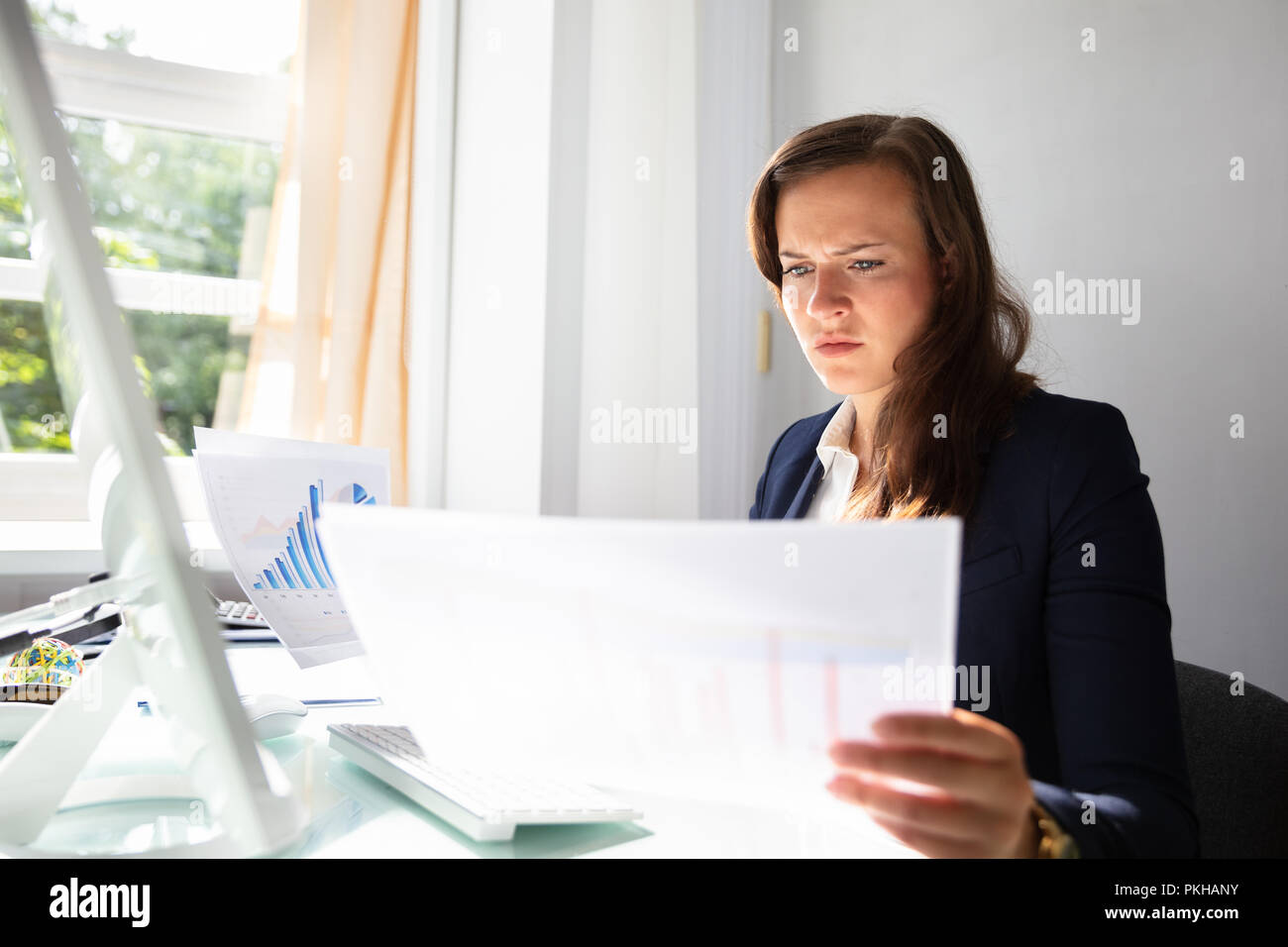 Konzentrierte Junge Geschäftsfrau auf Dokumente im Büro Stockfoto
