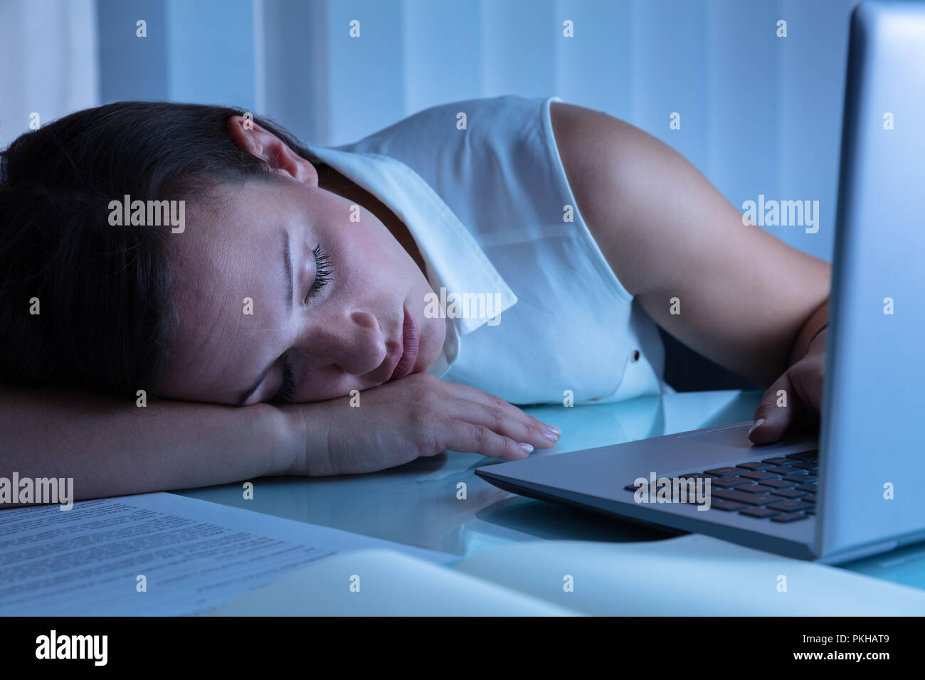 Geschäftsfrau Nickerchen im Büro mit Laptop auf dem Schreibtisch Stockfoto