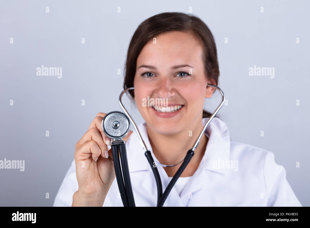 Portrait eines glücklichen jungen Arzt Holding Stethoskop Stockfoto
