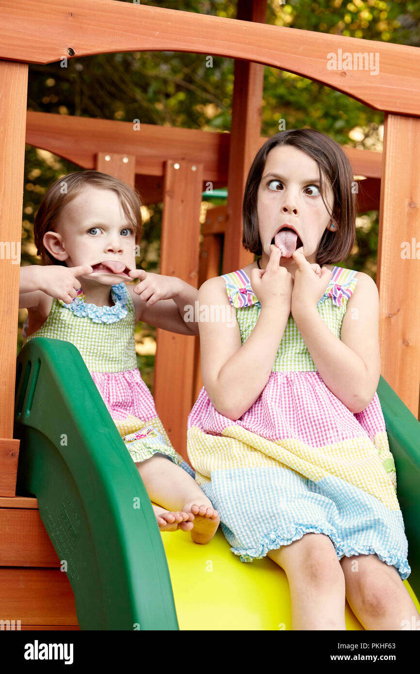 Kleine Mädchen spielen und lustige Gesichter Stockfoto