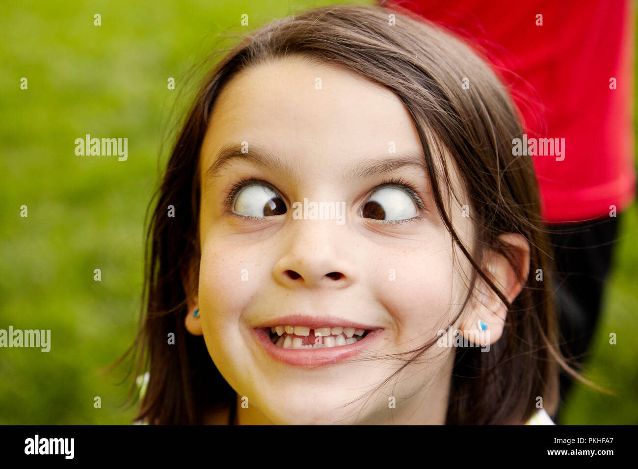 Kleine Mädchen spielen und lustige Gesichter Stockfoto