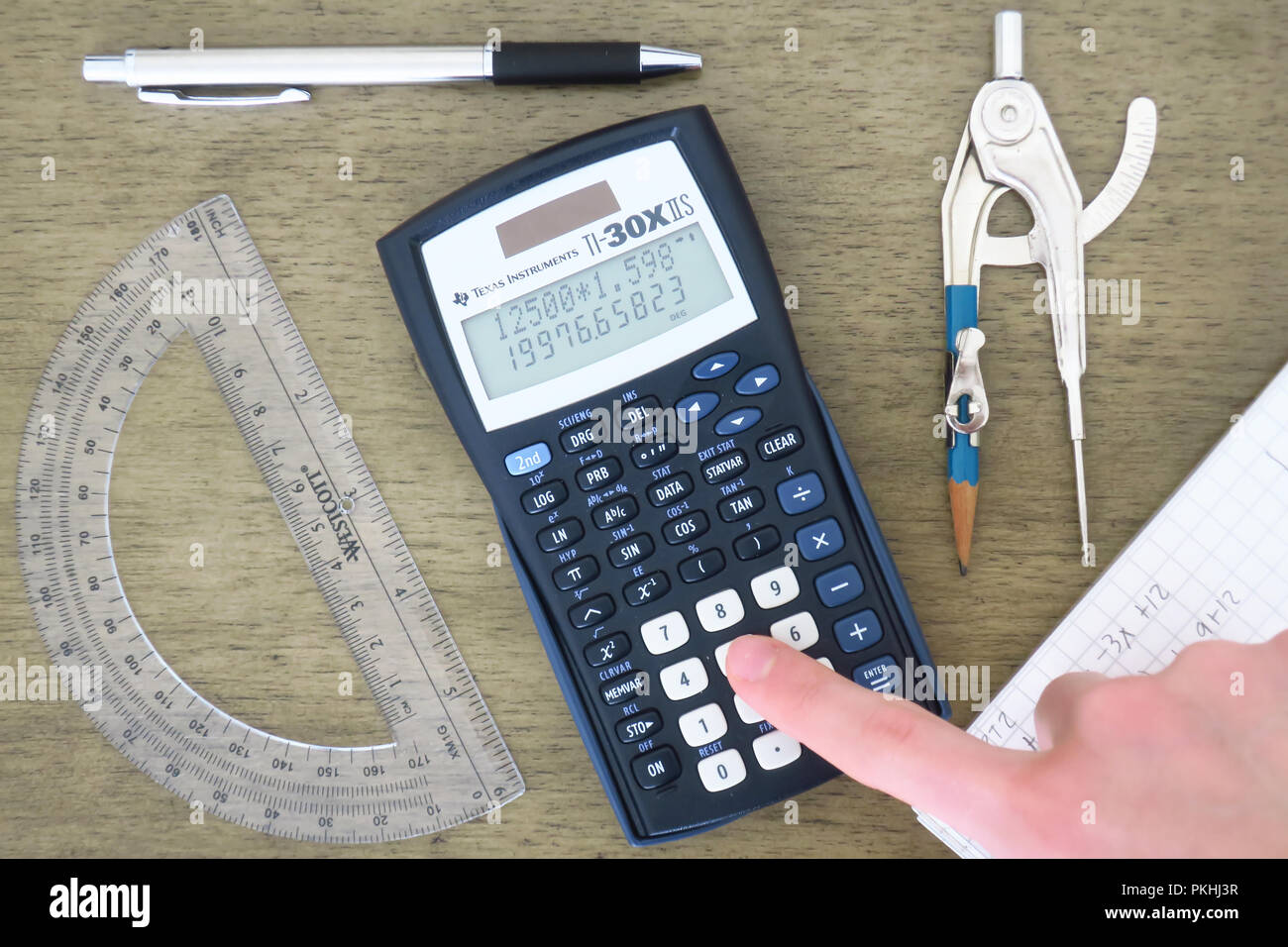 Ein Rechner, protactor, Bleistift, Kompass, Stift und graph Papiere auf einen Tisch. Stockfoto