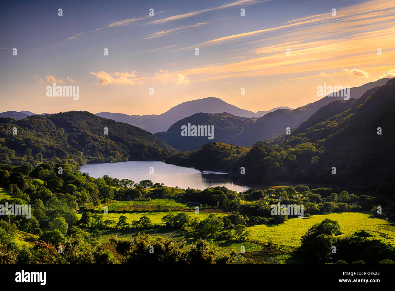 Die Sonne scheint über einen Berg und in Llyn Gwynant, Snowdonia (Eryri), Wales (Cymru), Großbritannien Stockfoto