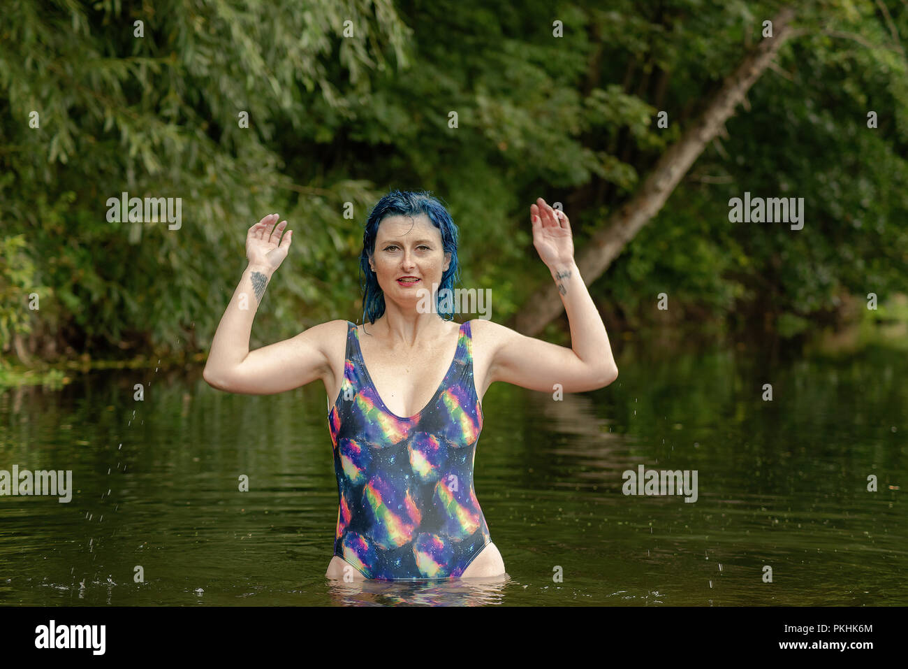 Eine blaue behaarte Frau in einem Badeanzug frolics in einem Fluss  Stockfotografie - Alamy