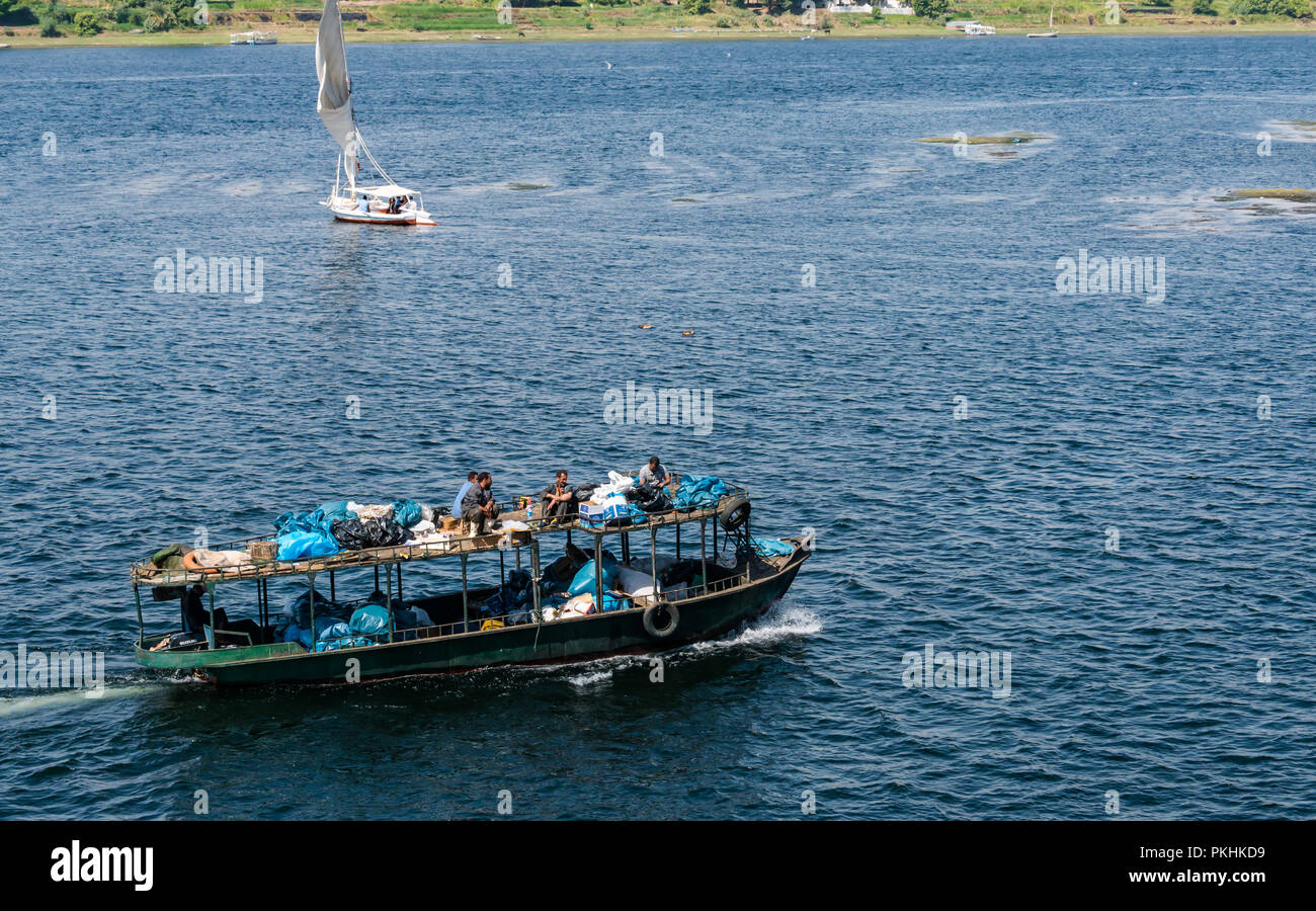 Flussboot, das Abfall transportiert, mit Männern, die auf dem Bootsdach sitzen, Nil, Assuan, Ägypten, Afrika Stockfoto