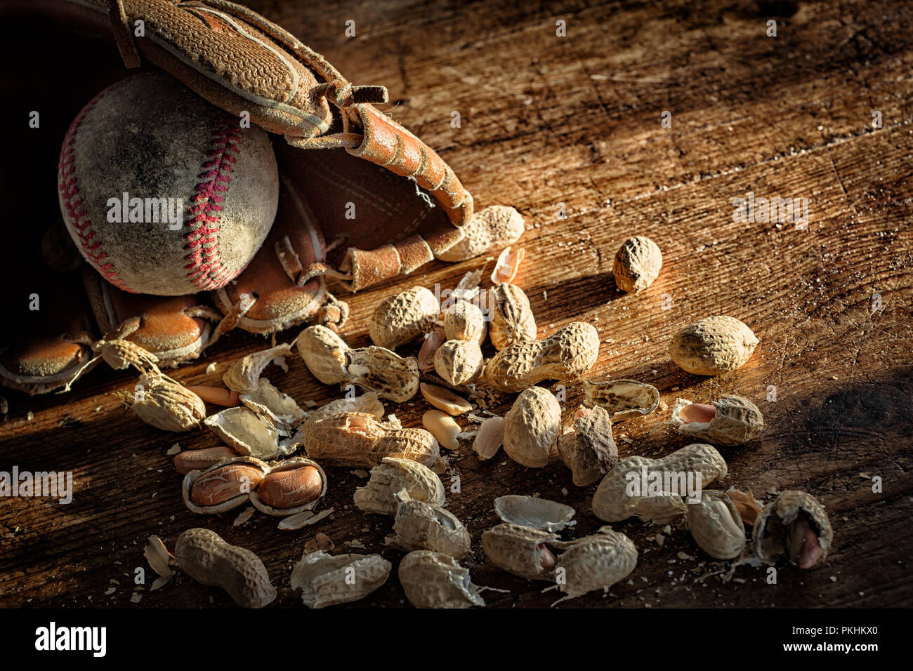 Baseball, Handschuh und alten Ball auf rustikalem Holz mit verstreuten Erdnüsse und Muscheln. Thema für Amerikas Sport. Vintage Look and Feel. Kopieren Sie Platz. Stockfoto