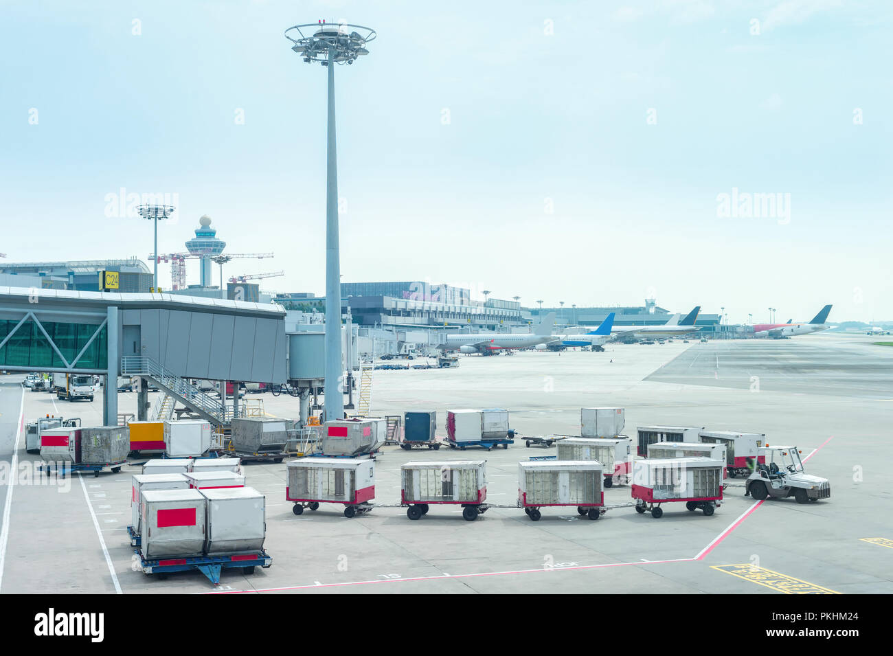 Gepäck Kutschen durch die Gangway am Changi Airport Terminal mit Flugzeugen, Singapur Stockfoto
