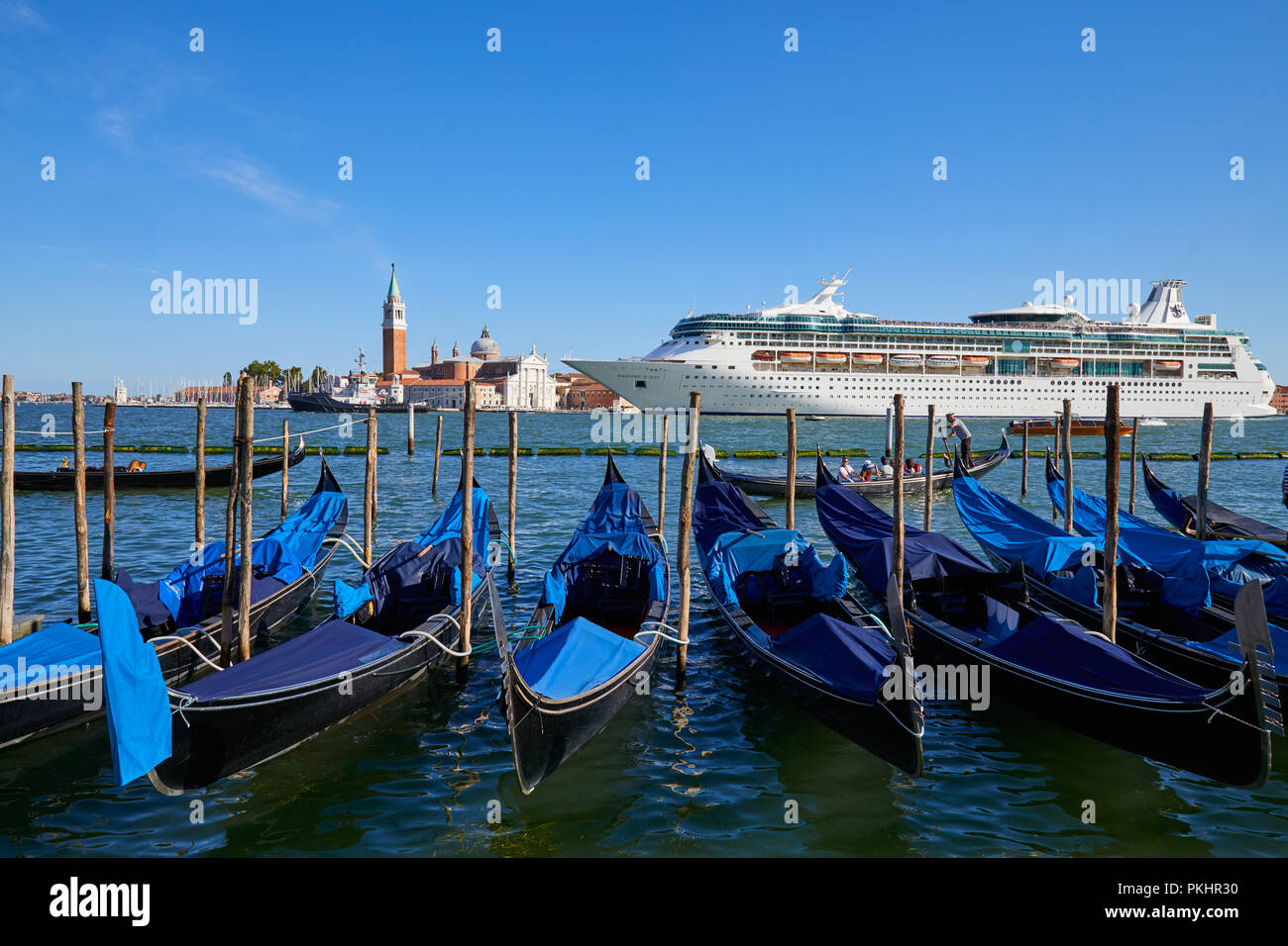 Venedig, Italien, 12. AUGUST 2017: Große weiße Kreuzfahrtschiff vorbei an der Gondeln und San Giorgio Maggiore Basilika in Venedig am Morgen, blauer Himmel in einem Stockfoto