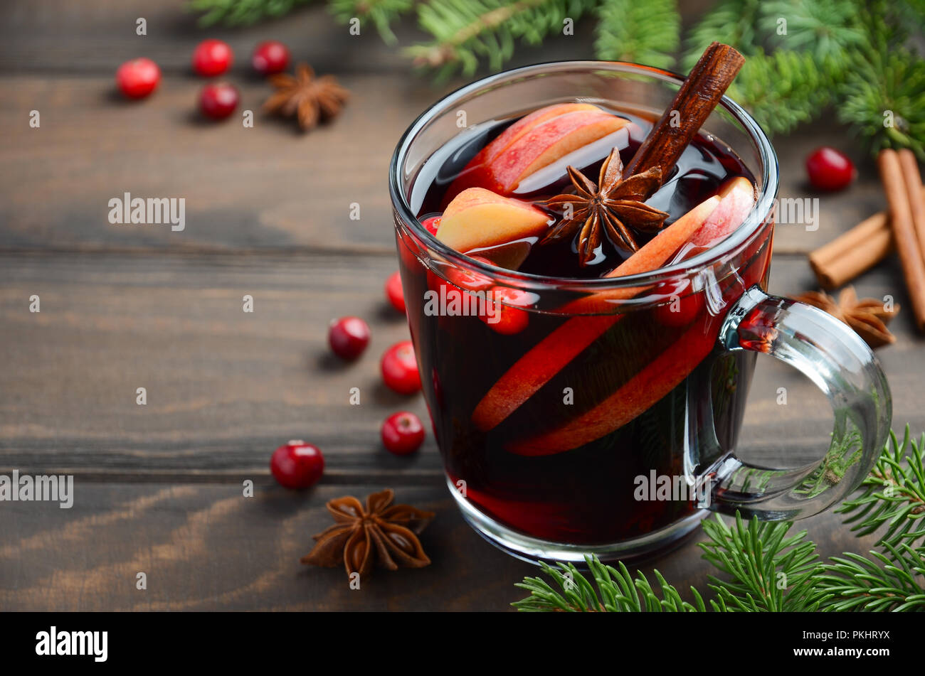 Weihnachten Glühwein mit Apfel und Preiselbeeren. Urlaub Konzept dekoriert mit Tannenzweigen, Preiselbeeren und Gewürzen. Stockfoto
