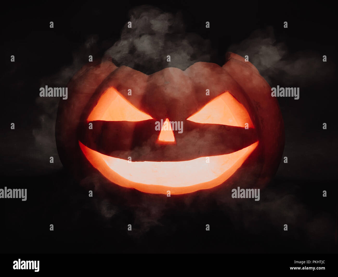 Halloween Kürbis scary face Jack o Lanternon auf dunklem Hintergrund Stockfoto