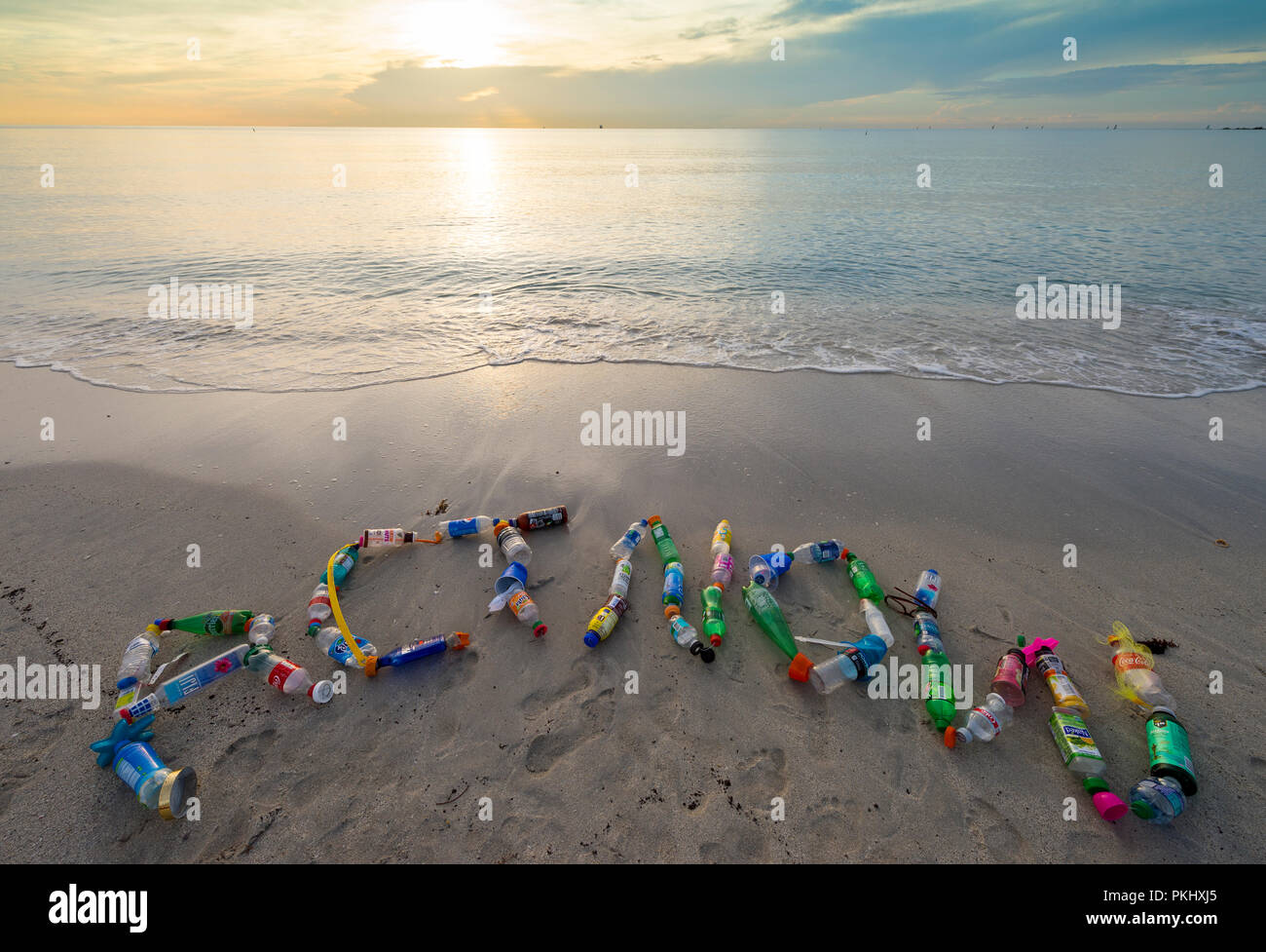 MIAMI - ca. Juni, 2018: "HANDELN SIE JETZT, "in den Sand mit Plastikmüll am Strand von Miami gesammelt geschrieben, eine Erinnerung zu Verringern, Wiederverwenden, Recyceln Stockfoto