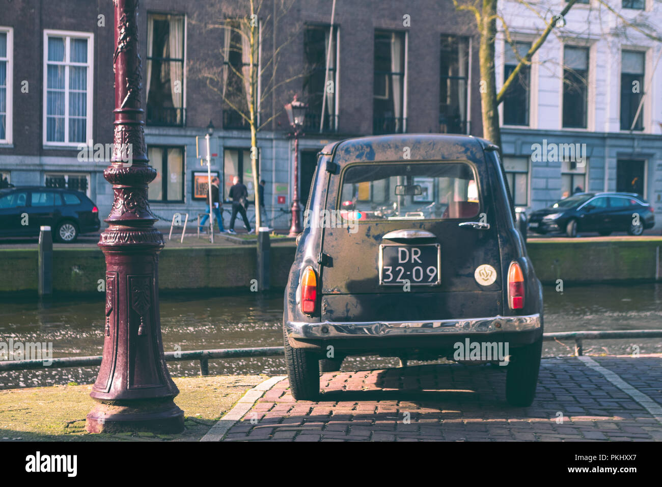 Alte Auto in der Nähe einer Gracht in Amsterdam geparkt Stockfoto