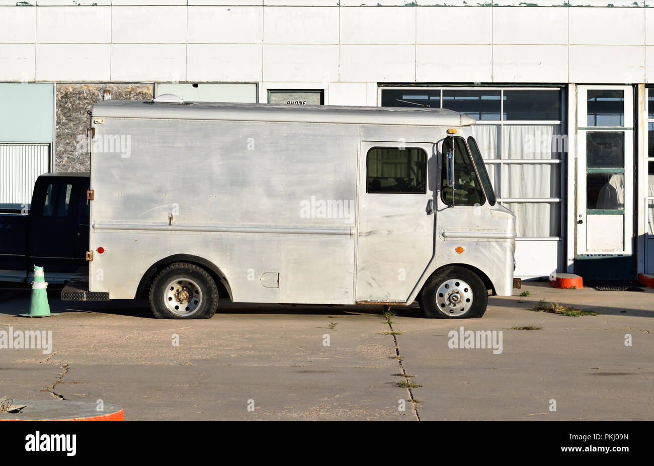 Silber Lieferwagen vor eine Werkstatt mit zwei Platten Reifen gebrochen Stockfoto