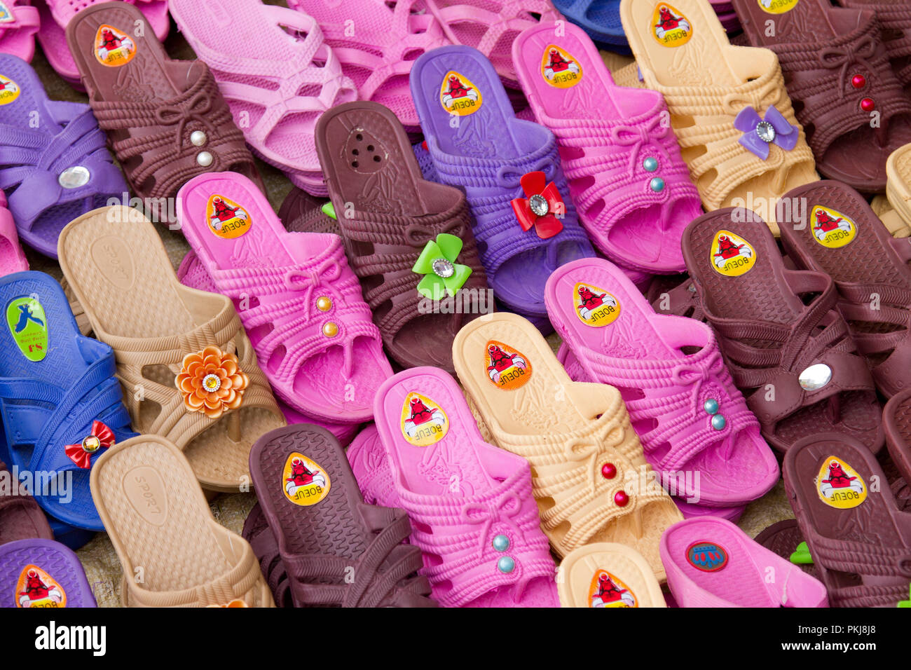 Gruppe von farbigen Kunststoff Schuhe für Verkauf an den madagassischen Farmers Market, Madagaskar, Afrika Stockfotografie
