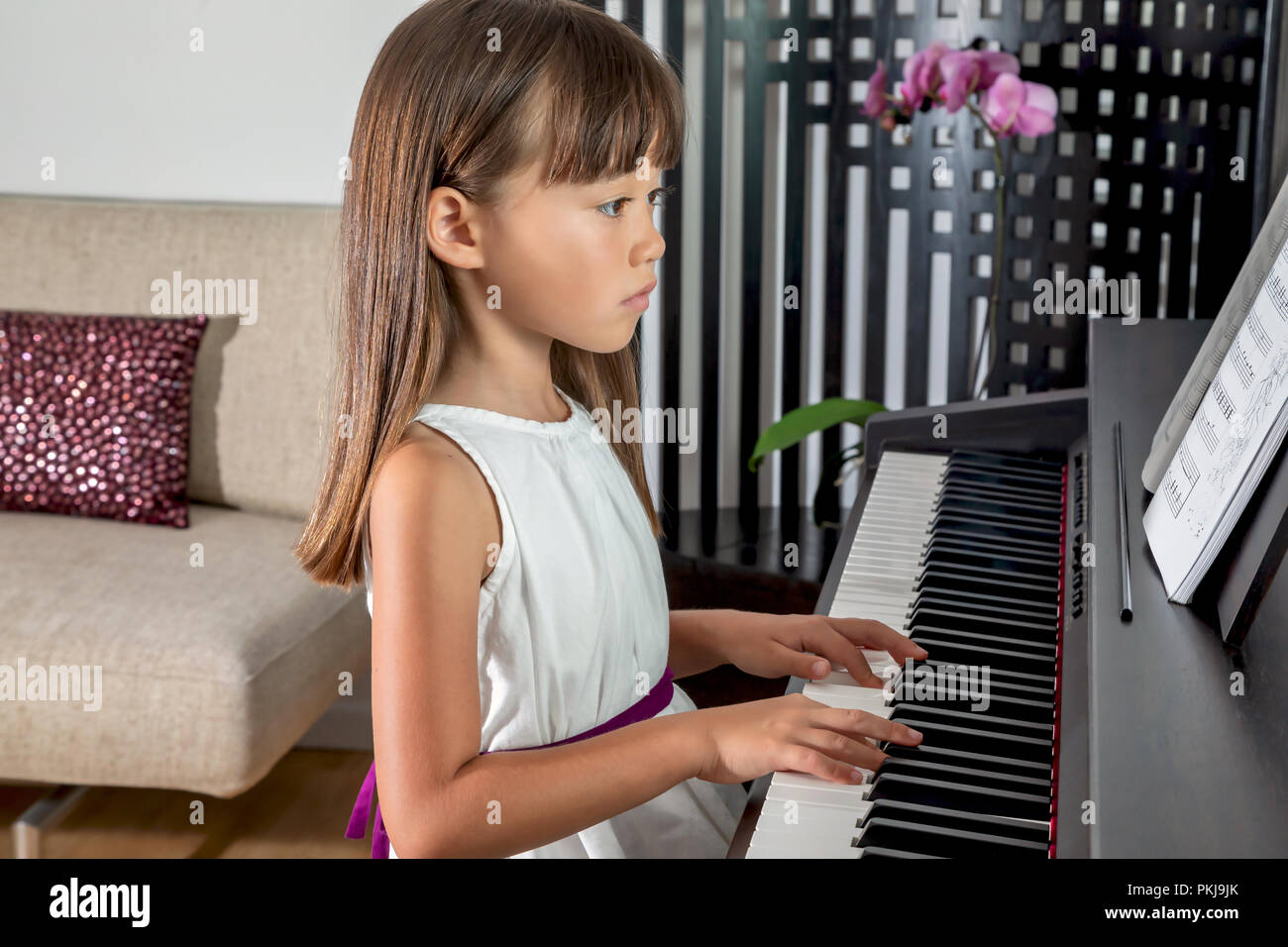 Sechs Jahre altes Mädchen üben das Klavier Stockfoto