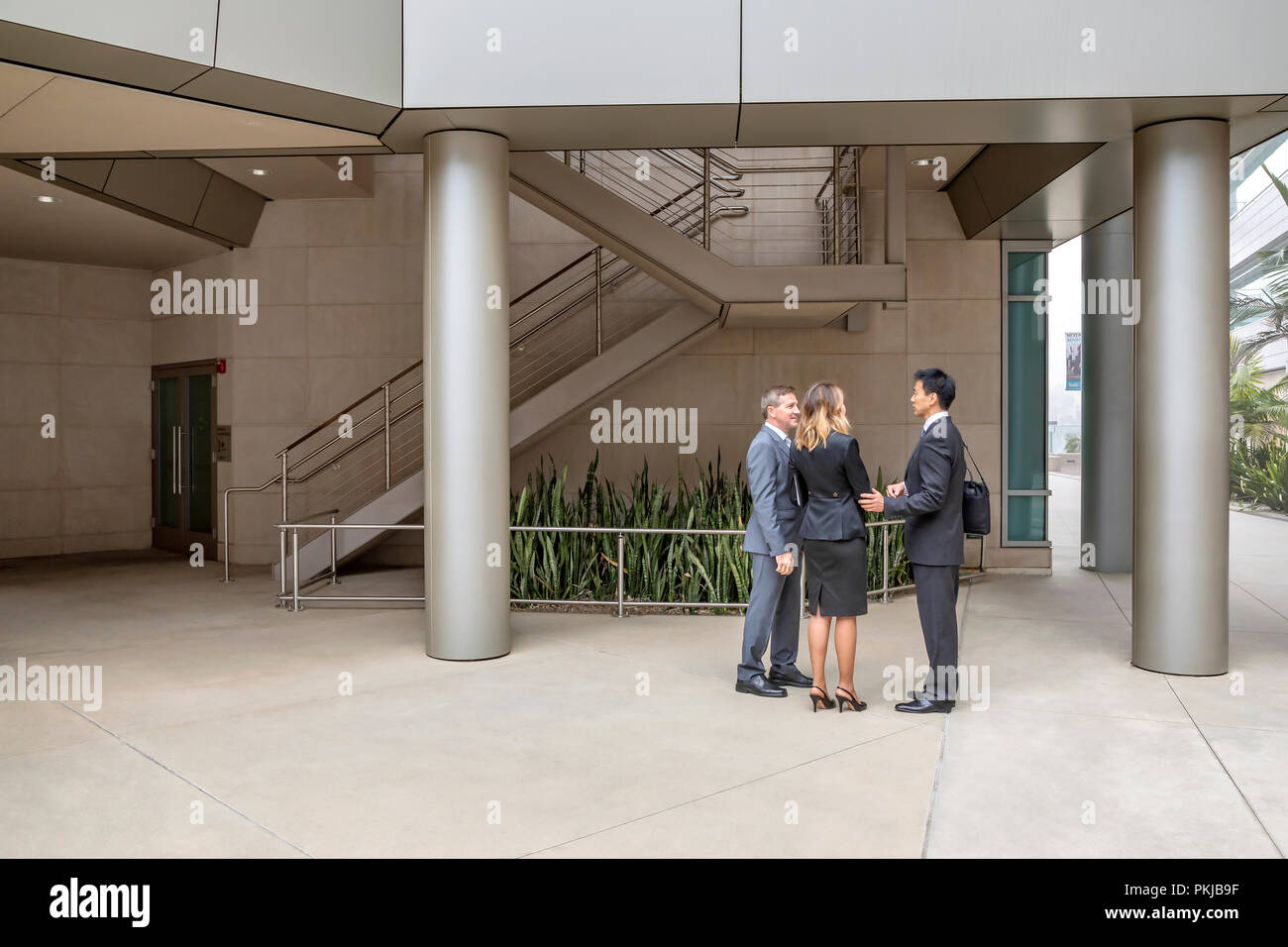 Drei Führungskräfte sprechen innerhalb Ihres Bürogebäudes Stockfoto