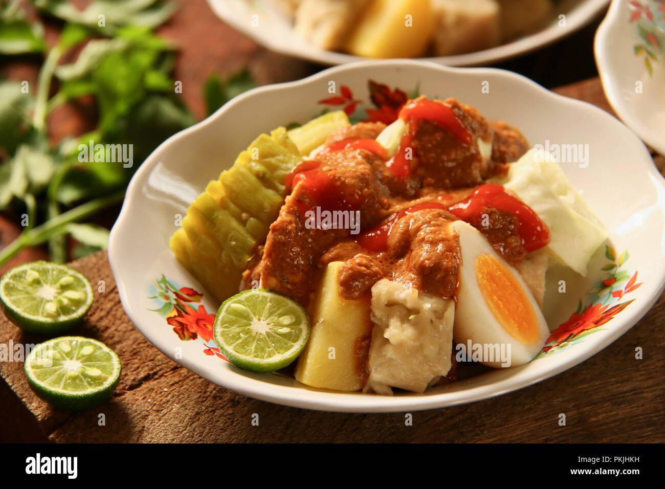 Siomay Bandung, einer beliebten Straße Futternapf von Fisch Kuchen Knödel mit Ei, Kartoffel, bitteren Kürbis, Tofu, Kohl und würzige Erdnuss-sauce. Stockfoto