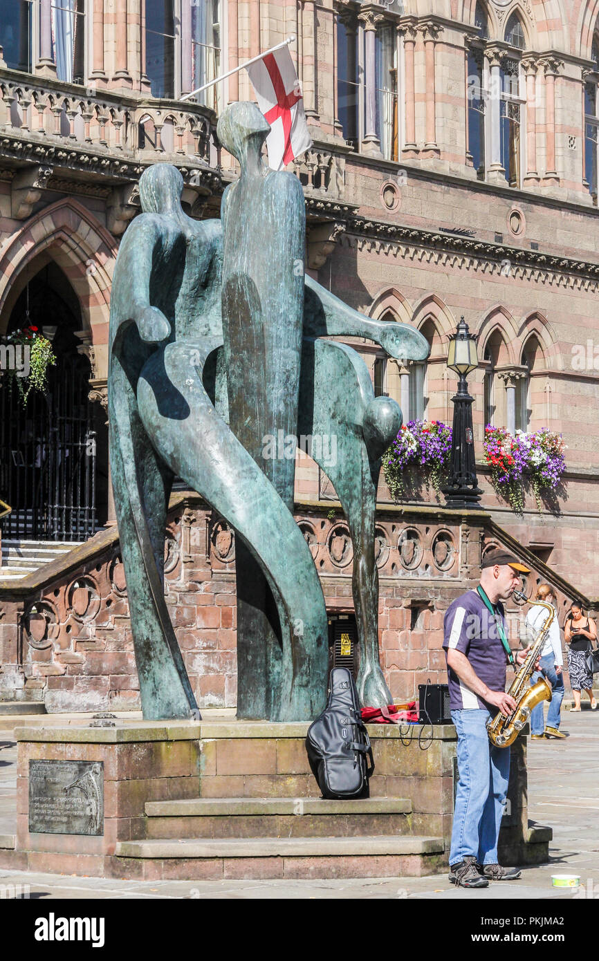 Chester, England - 16. August 2016: ein strassenmusikant spielt das Saxophon von Statue vor dem Rathaus. Die Statue ist von Stephen Broadbent. Stockfoto