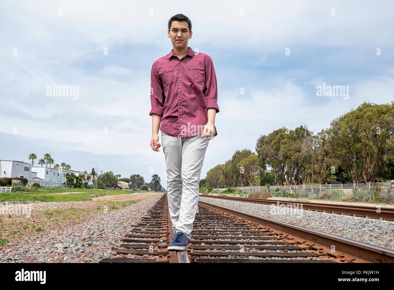 Junge Mann zu Fuß auf Schienen Stockfoto
