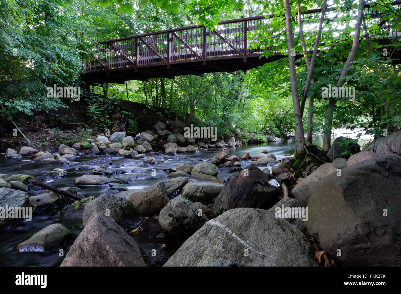 Seidigen wasser Szene Landschaft stream Anschließen an einen Fluss mit einem schönen Spaziergang Brücke über den Pass ein wenig weiter zurück Stockfoto