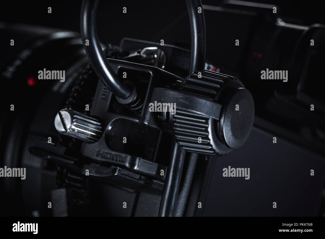 Ein Kabelhalter auf einem Sony a7rii spiegellosen Kamera vor einem dunklen Hintergrund. Stockfoto