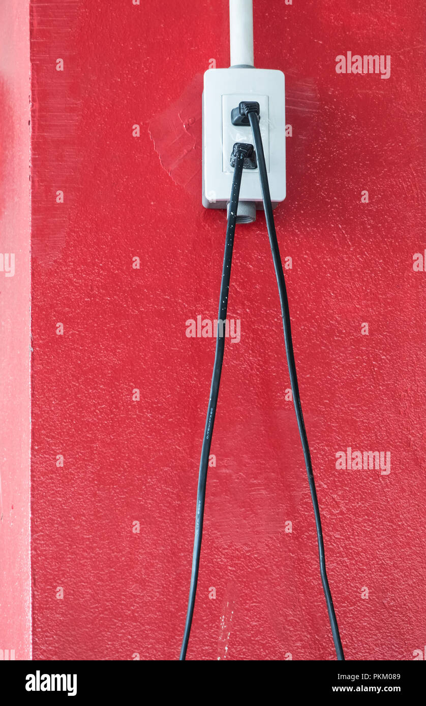 Kunststoff weiß Sockel mit den elektrischen Draht auf der roten Säule im Bürogebäude. Stockfoto