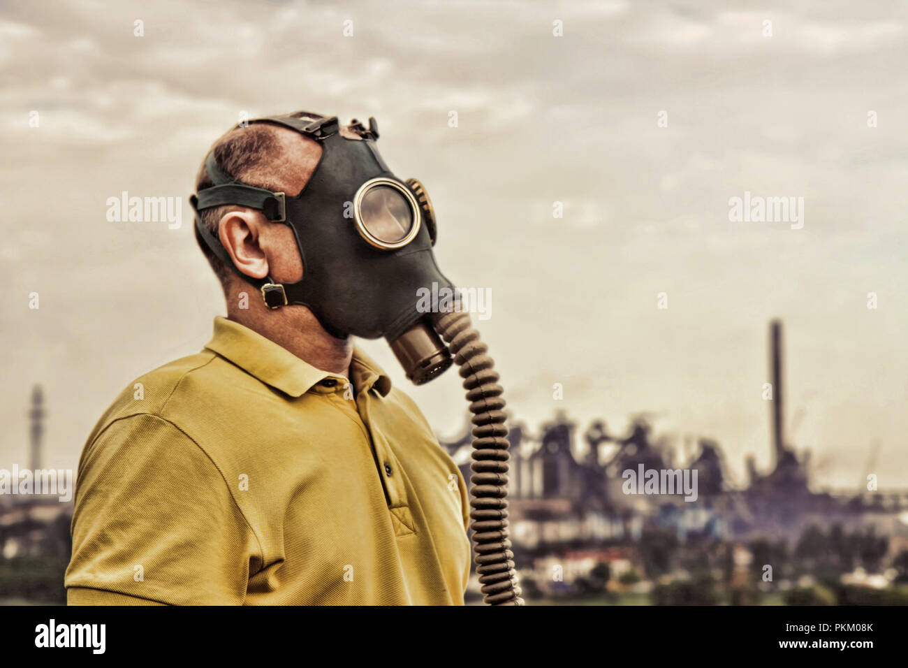 Mann mit Gasmaske vor der industriellen Fabrik stehen. Grunge style getonten Bild. Stockfoto