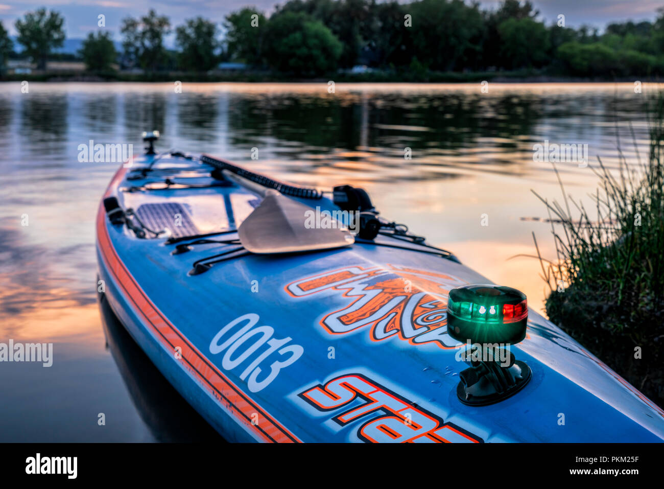 Fort Collins, CO, USA - 14. Juli 2018: Eine racing Stand up paddleboard von Steuerbord mit einem Paddel, Safety Leash und navigatorischen Leuchten nach Einbruch der Dämmerung auf La Stockfoto