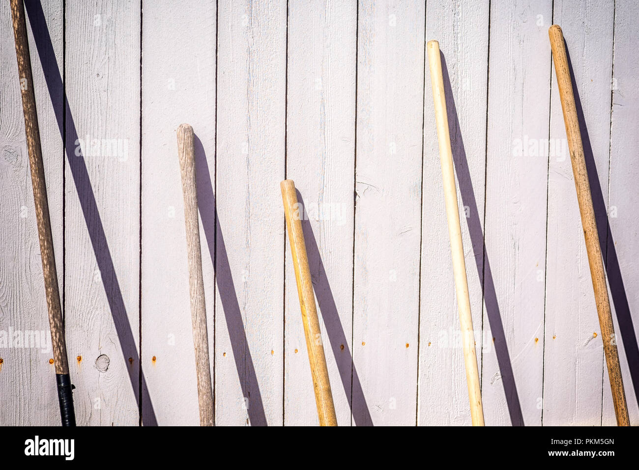 Holzgriffe von gartengeräte Gleitstift gegen einen Zaun. Stockfoto