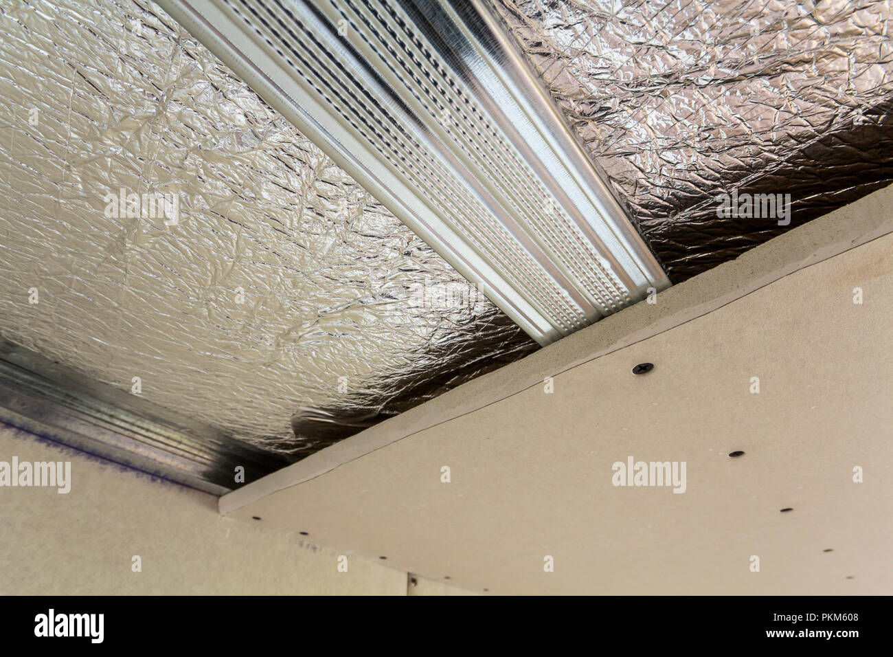 Detail des unfertigen Zimmer im Bau und Renovierung mit silber Aluminium  Folie Isolierung an Wänden und Decke und Trockenbau zu Metall p  angeschlossen Stockfotografie - Alamy