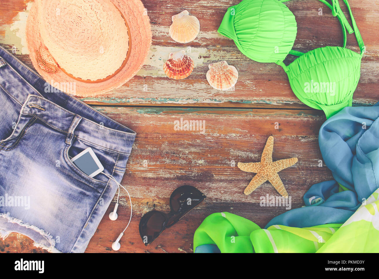 Sommer Damen Bekleidung und Zubehör: Hut, Badeanzug, denim Shorts, Pareo, Sonnenbrille, Muscheln. Ansicht von oben. Stockfoto