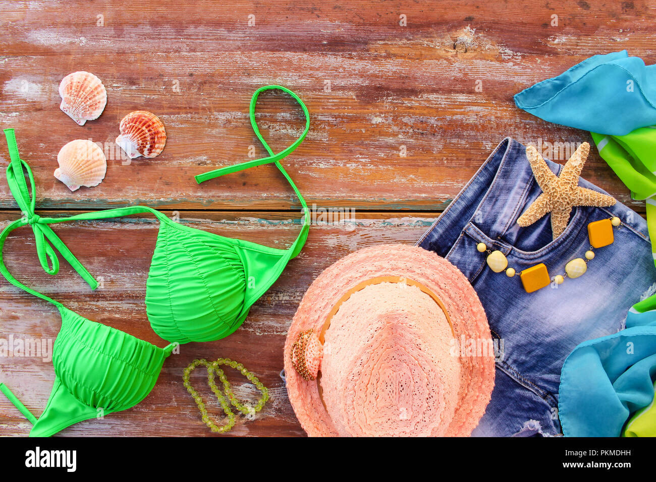 Sommer Damen Bekleidung und Zubehör: Hut, Badeanzug, denim Shorts, Pareo, Muscheln. Ansicht von oben. Stockfoto