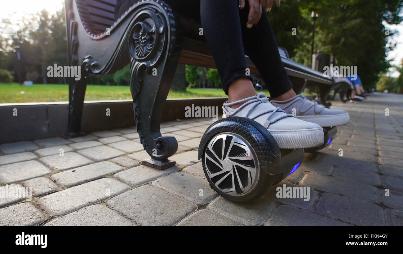 Mädchen nachdenklich auf der Bank sitzen im Park. Ihre Füße sind auf der Gyro. Sommer. Stockfoto