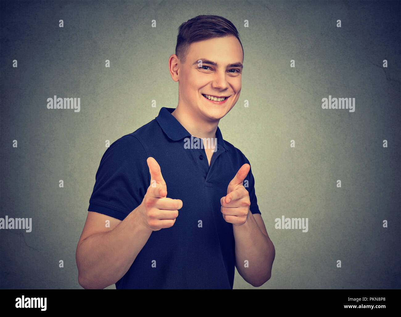 Inhalte positiv Mann an der Kamera zeigt mit Fingern cool aussieht und wie auf grauem Hintergrund Stockfoto