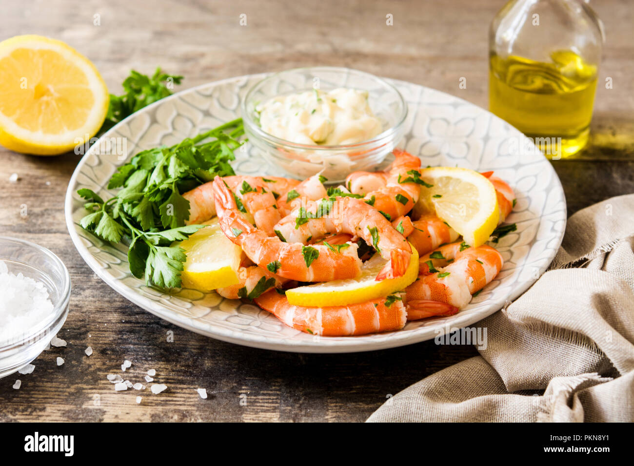 Gegrillte Garnelen, Petersilie und Zitrone auf hölzernen Tisch Stockfoto