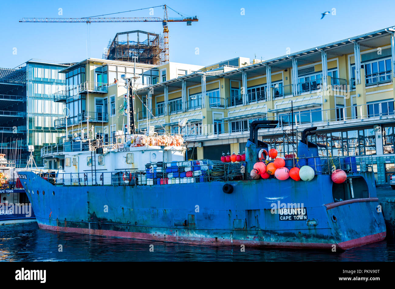 Die Ubuntu Schiff, ein Fischereifahrzeug, und neue Gebäude dahinter in Kapstadt, Südafrika Stockfoto