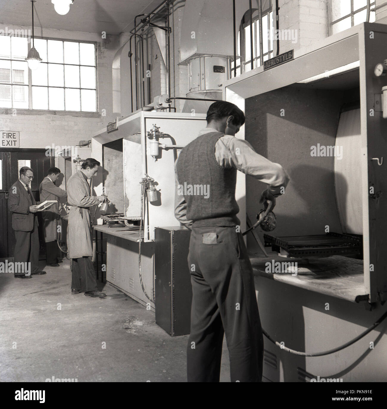 1950, historische, Arbeitnehmer mit den Industrial Metal paint Sprayer an den Einzelnen schützenden Kabinen in der Fabrik von Bush Radio, führenden britischen Hersteller von Radios und Fernseher in dieser Ära. Stockfoto