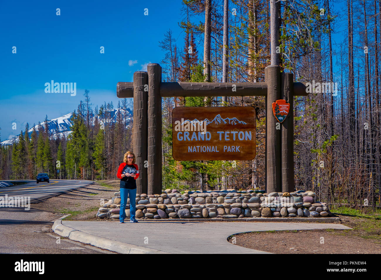 YELLOWSTONE, Montana, USA, 24. Mai 2018: Nicht identifizierte Frau in einer informativen Zeichen des Grand Teton im Yellowstone National Park warten Stockfoto