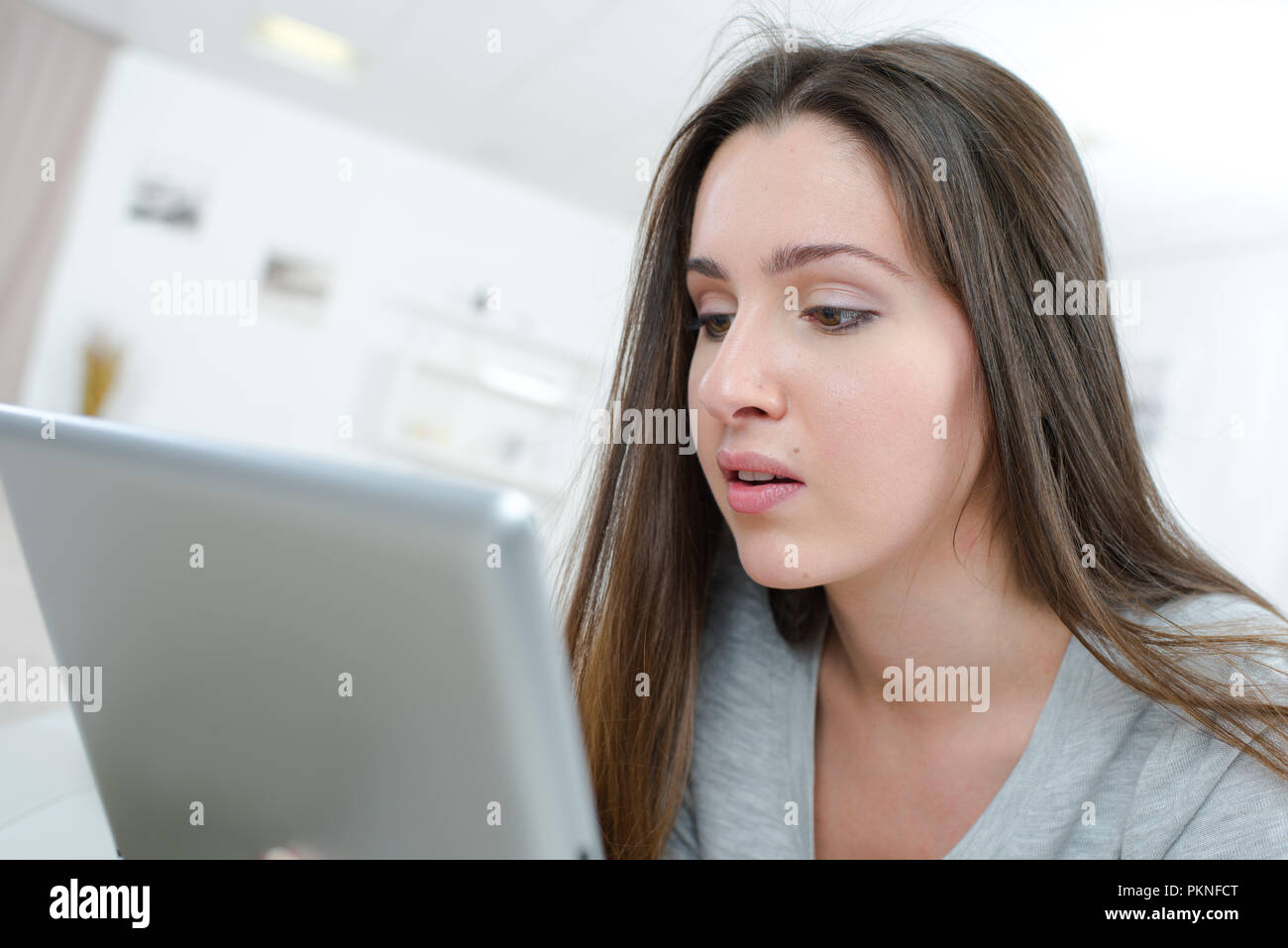 Glückliche junge Frau mit Tablet-PC auf Sofa Stockfoto