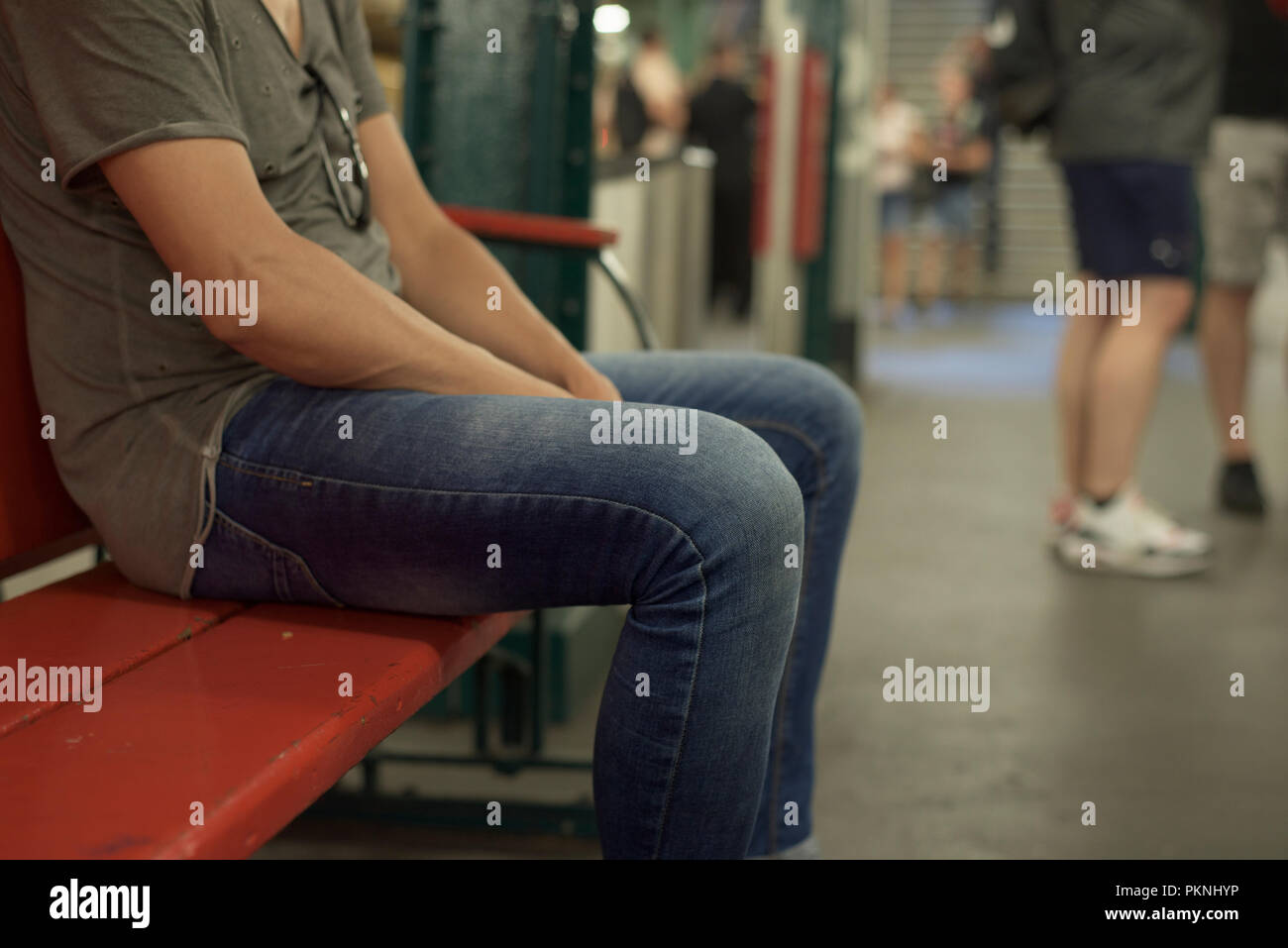 Nahaufnahme eines jungen kaukasischen Mann legere Kleidung in einer Bank sitzen in einer U-Bahn Station Stockfoto